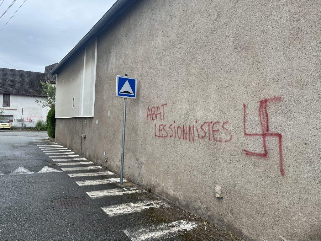 Des tags antisémites sur les murs de Danjoutin au premier plan, mais aussi sur la maison blanche en fond, ce vendredi 14 juin. | ©Le Trois - H.G. 