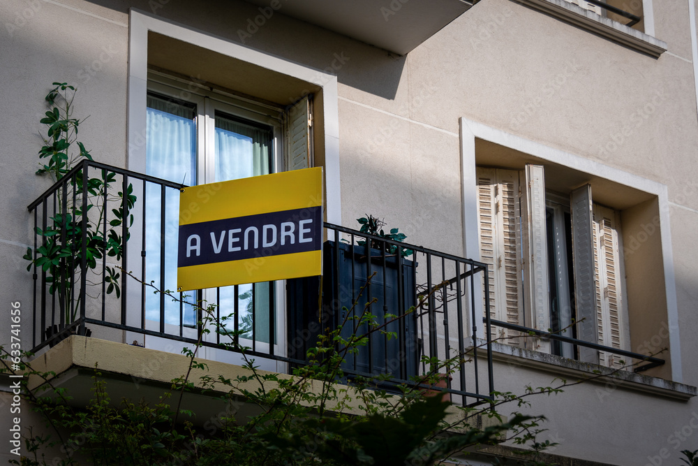 Appartement avec une pancarte "à vendre" accrochée sur le balcon.