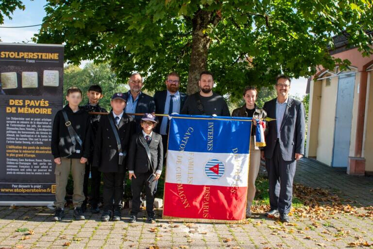 Quatre jeunes porte-drapeaux et des membres de l'Unadif portent un drapeau français.